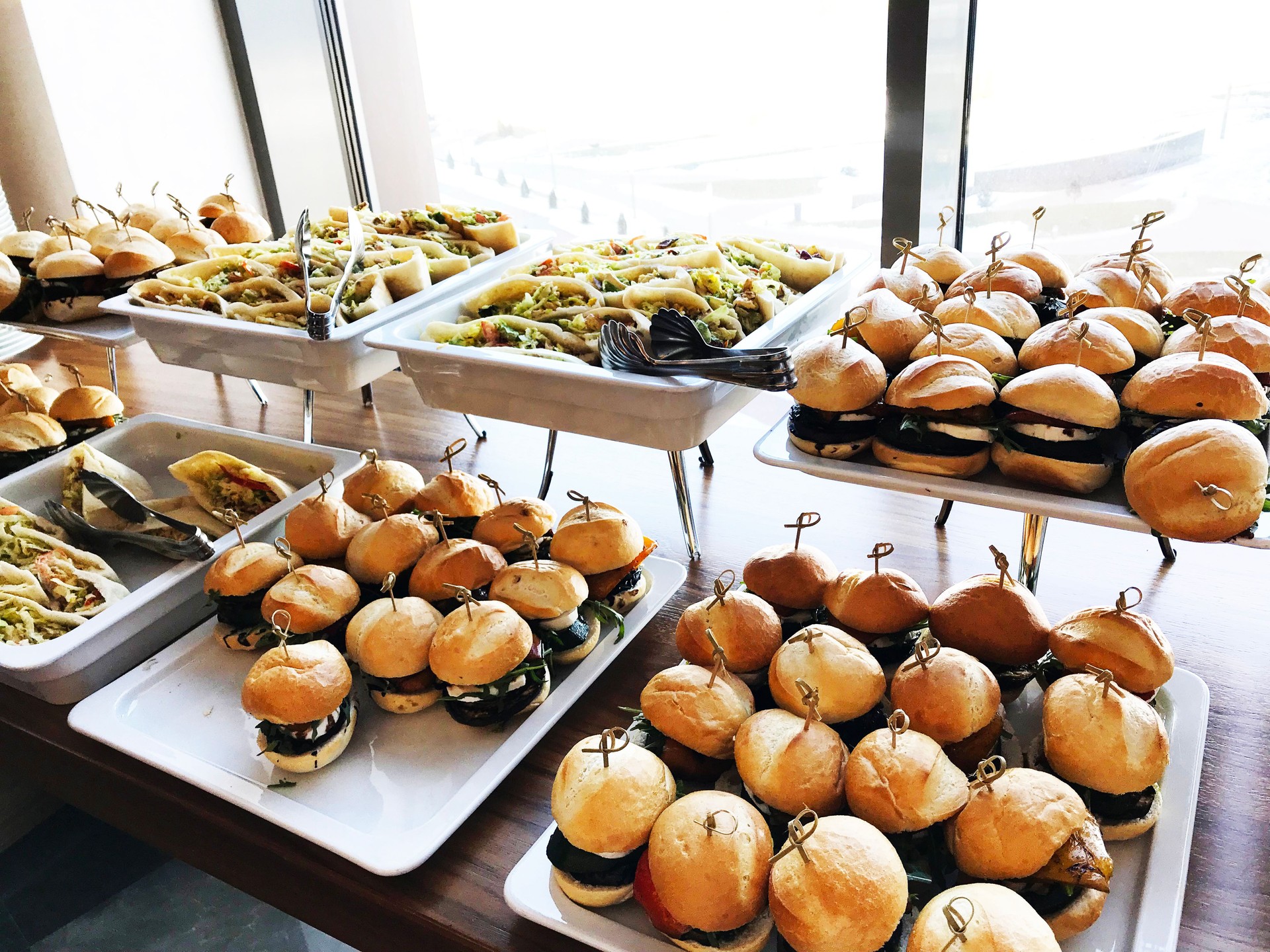 Buffet table with small hamburgers, sandwiches and vegetables. Catering service at the corporate business party or meeting